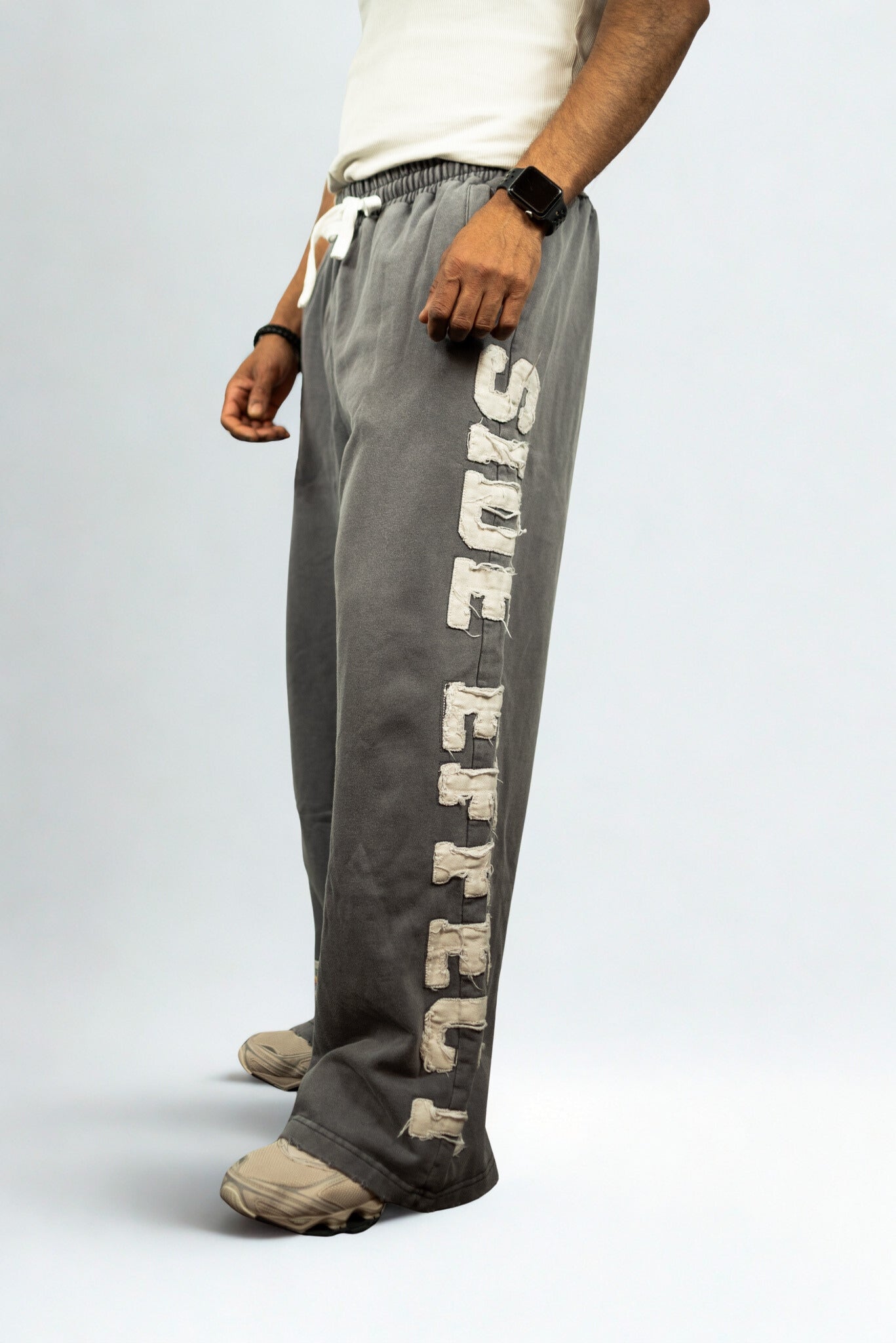SIDE EFFECT oversized grey jogger pants with frayed appliqué logo, street-ready design inspired by revolution culture